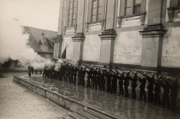 Fronleichnamsschießen vor der Stiftskirche in den 1930er Jahren. Die Steinbacher Fronleichnamsprozession wurde seit den 1870er Jahren von einer „freiwilligen Miliz“ begleitet. Fotograf unbekannt, Original in Privatbesitz (StadtA Schwäb. Hall DIG 06442)
