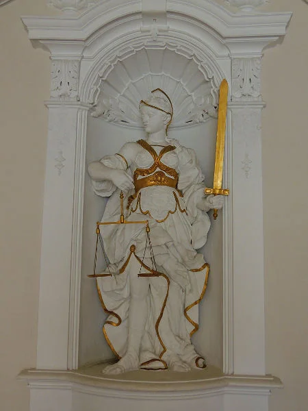 Skulptur „Die Gerechtigkeit“ von Emanuel Pighini und Tomas Gavoni um 1735. Sie folgt weitgehend der klassischen allegorischen Darstellung der „Justitia“: Waage und Schwert stehen für Abwägen und Urteilen. Die ansonsten häufige Augenbinde für Unparteilichkeit fehlt in dieser Darstellung. März 2017. Foto: Daniel Stihler (StadtA Schwäb. Hall DIG 10029)