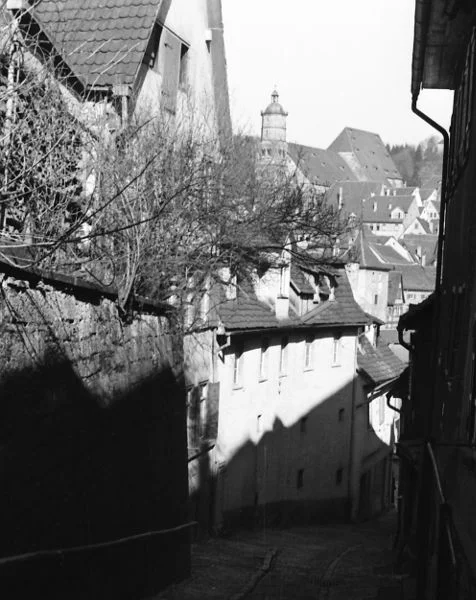 Blick durch die Brüdergasse in Richtung Kocher, das Haus Brüdergasse 6 ist durch die Gartenmauer und das Gestrüpp teilweise verdeckt, unterhalb liegt das ebenfalls nicht mehr existierende Anwesen Brüdergasse 2-4. Undat., um 1928-1934. Fotograf unbekannt (StadtA Schwäb. Hall DIG 05923, Original: Ivo Lavetti / www.nostalgus.de, alle Rechte vorbehalten)