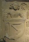 Detail der Bauinschrift des Pulverturms von 1490, Eine Figur hält das Wappen des Baumeisters Hans Mung von Öhringen. Heute im Hällisch-Fränkischen Museum, November 2013. Foto: Daniel Stihler (StadtA Schwäb. Hall DIG 05169)