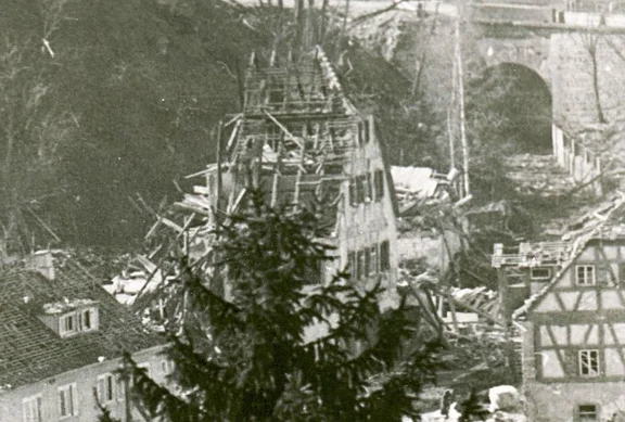 Beim amerikanischen Luftangriff vom 13. Februar 1945 wurde der hintere Teil des Hauses Nr. 11 durch Bombentreffer weggerissen, wobei der Besitzer des Hauses, Bezirksnotar i.R. Robert Laux, getötet wurde (Bildmitte, am linken Rand der „Schafstall“) (StadtA SHA FS 38466)