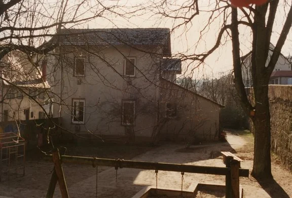 Blick über den Spielplatz auf die nordwestliche Stirnseite, kurz vor dem Abbruch, 1994. Foto: Baurechtsamt Schwäb. Hall (StadtA SHA DIG 03333)