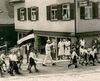 Bei einem Kinderfestumzug vermutlich 1933. Man beachte den „Deutschen Gruß“ des weißgekleideten Erwachsenen in der Bildmitte und die halb verdeckte Hakenkreuzfahne der Gruppe vor ihm (StadtA Schwäb. Hall FS 04402)