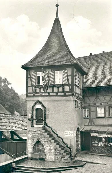 Der mittlerweile mit einer Treppe in den 1. Stock und einem Brunnen versehene Rotstegturm diente Ende der 1930er Jahre als SS-Heim. Das Schild neben der Treppe trägt die Aufschrift  ''SS-Sturmbann III, 13. Standarte'', das über dem Eingang in den 1. Stock ''SS-Mann! Deine Ehre heißt Treue!''. Über diesem Schild befindet sich ein Stein mit einem Hakenkreuz. Der Schmuck deutet an, dass das Bild wahrscheinlich während eines nationalsozialistischen Feiertags entstand. Foto von 1939 oder früher (StadtA Schwäb. Hall PK 03462)