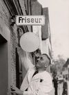 Der Friseur August Steinbach hängt sein Schild für eine Buntmetallsammlung während des Zweiten Weltkriegs ab, ca. 1941. Foto: Hans H. Hartmann (StadtA Schwäb. Hall FS 02029)