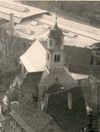 Blick von der Comburg auf St. Johannes, vermutlich um 1950, nach der Entfernung des Putzes am Turm und der Freilegung der romanischen Biforien durch Eduard Krüger. Fotograf unbekannt (StadtA Schwäb. Hall PK 01211)