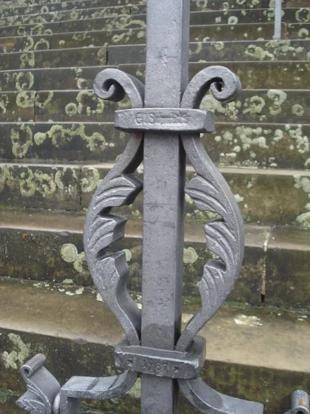 Detail des schmiedeeisernen Geländers mit Signatur des Kunstschmieds Emil Schmidt und Datum „1987“,  Februar 2013. Foto: Daniel Stihler (StadtA Schwäb. Hall DIG 03270)